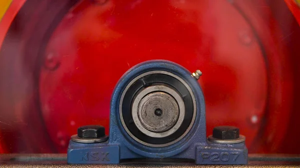 Close-up de cilindro vermelho rotativo. Mídia. Girando tambor industrial é de cor vermelha. Parafusos grandes com cilindro industrial rotativo — Fotografia de Stock