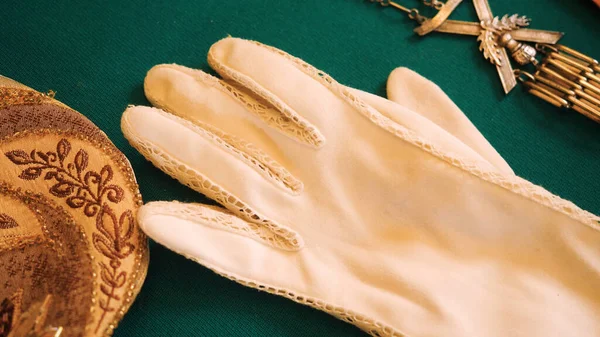 Vintage gloves and jewelry. Stock footage. Close-up of vintage gloves and accessories lying on green background. Vintage accessories in museum window