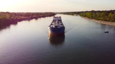 Volga 'da giden kargo gemisinin üst görüntüsü. Görüntü. Sahilin arka planında, tatilcilerle birlikte nehirde kargo taşımak için uzun bir tekne. Yaz aylarında taşıma araçları iç kısımlarda