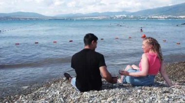 Güzel bir çiftin kırmızı şarap içip tıkırdadığı arka manzara. Kavram. Aşıkların elleri deniz kenarında birlikte vakit geçirirken şarap kadehlerini tokuşturur, tatil kavramını..