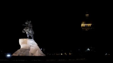 Aziz Petersburg, Rusya 'da gece vakti Büyük Peter' ın heykeli. Başla. Senato Meydanı 'ndaki Bronz Süvari Anıtı. Saint Isaac Katedrali' nin arka planındaki sokak lambasının ışığı altında.
