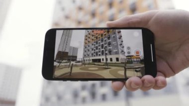 Erkek ellerinin geniş açı modunda akıllı telefondan bir video kaydetmesini kapat. Başla. Çok katlı bir binayı yeni bir cihazla çekmek inanılmaz kalitede bir resim..