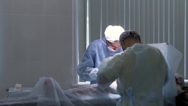 Медичний фон з чоловіками-лікарями на роботі. Дія. Два чоловічих хірурги в уніформі, що виконують операцію на серці пацієнта в клініці кардіохірургії . — стокове відео