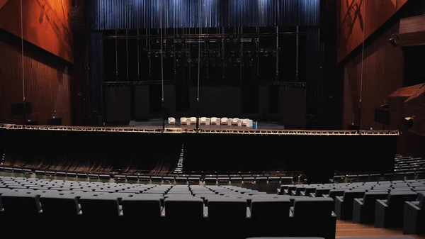 Salle de réunion avant la conférence éducative. Les médias. Homme montant les escaliers entre des rangées vides de chaises devant la scène avec des fauteuils beiges. — Photo