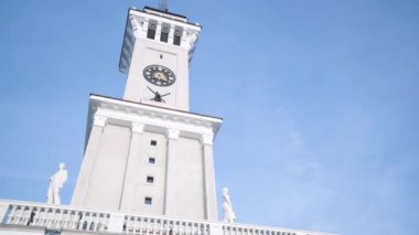 Mavi gökyüzünün arka planında beyaz saat kulesi. Başla. Gökyüzünün arka planındaki güzel beyaz saat kulesinin alt manzarası. Moskova 'daki Kuzey nehir istasyonunun saat kulesi.