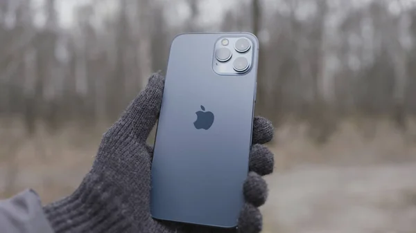 Nueva York, EE.UU. - 11.11.2020: Guante de punto hecho a mano con Apple iPhone 12 Pro Max Action. Demostración al aire libre del logotipo trasero y las cámaras. — Foto de Stock
