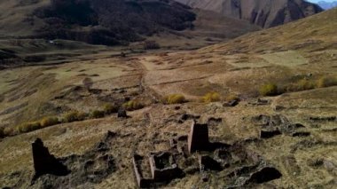 Dağlarda antik mezar kalıntıları olan eski bir mezarlık. Görüntü. Ağaçlarla kaplı dağ yamacının arka planında tuğla enkazları olan antik mezarlığın havadan görünüşü.