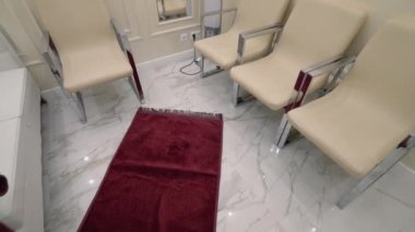 Koltukları ve koltukları olan parlak bir iç mekan. Başla. Sandalyeli ve kanepede havluyla kaplanmış kaplıca tedavileri için parlak giriş salonu. Işıl ışıl içi olan bir spa