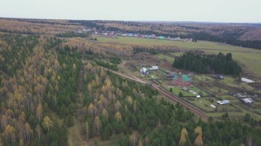 Küçük bir köyün üzerinden hava manzarası. Şarjör. Tarım faaliyetleri için ekolojik alan ve karışık sonbahar ormanı ve yeşil alan yakınında yaşayanlar için.
