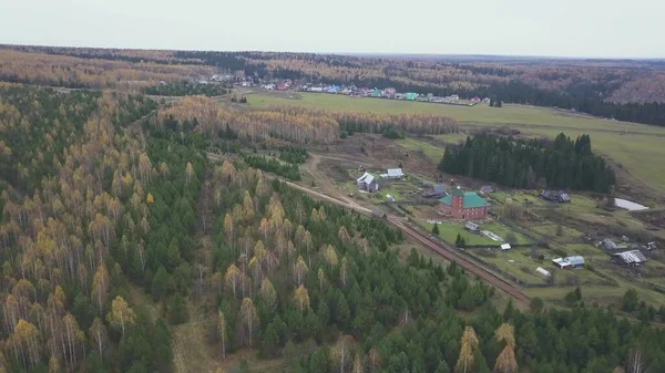 Küçük bir köyün üzerinden hava manzarası. Şarjör. Tarım faaliyetleri için ekolojik alan ve karışık sonbahar ormanı ve yeşil alan yakınında yaşayanlar için.