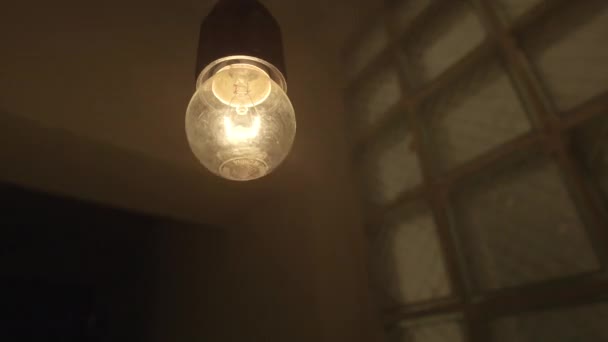 Vintage blikající visící žárovka. Záběry ze skladu. Detailní záběr staromódní blikající žárovky na stropě vchodu do budovy na pozadí zdí. — Stock video