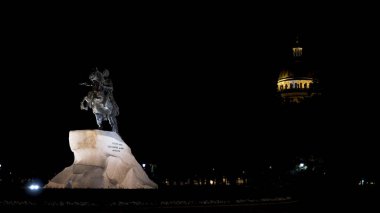 Aziz Petersburg, Rusya 'da gece vakti Büyük Peter' ın heykeli. Başla. Senato Meydanı 'ndaki Bronz Süvari Anıtı. Saint Isaac Katedrali' nin arka planındaki sokak lambasının ışığı altında.