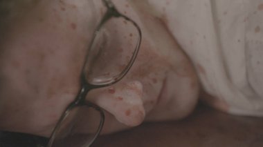 Adam kanlar içinde yatıyordu. Hisse. Gözlüklü genç adamın yerde yatarken canlanması. Adam kanlar içinde yerde yatıyor.