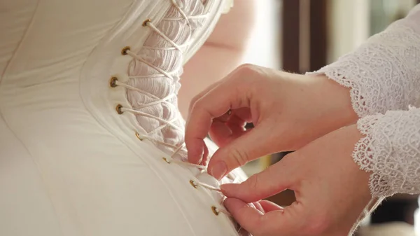 Vrouw in 19e-eeuws korset. Voorraadbeelden. Close-up van het dienstmeisje dat haar maîtresse helpt zich in korset te kleden. Details van deze vintage outfit met corset en voering — Stockfoto