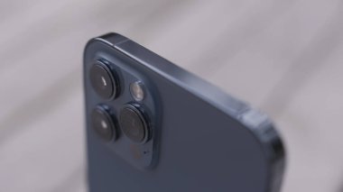 Üç kameralı güzel, koyu mavi bir akıllı telefonun detaylarını kapat. Başla. Modern teknoloji ve tasarım kavramı, beyaz arkaplanda izole edilmiş aygıt.