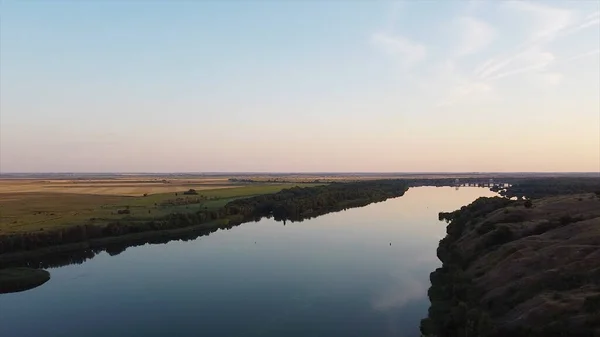 Prachtig panorama van de rivier die naar de horizon gaat en de blauwe lucht reflecteert. Beelden. Rivieroppervlak weerspiegelt prachtige blauwe lucht met wolken in de schemering. Bovenaanzicht van het landschap van de rivier fuseren met de hemel op — Stockfoto