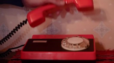 Eski bir telefon. Medya. Eski bir ev telefonunu alan adamın yakın çekimi. Telefonları kablo ve dönen dijital varillerle donatılmış. Geçmişten çağrı