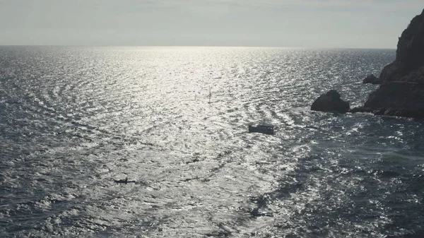 Vista aérea del avión no tripulado de pasajeros pequeño yate de crucero en el popular mar Egeo. Le dispararon. Efecto de cámara lenta, barco blanco flotando en aguas onduladas del mar bajo el sol brillante. — Foto de Stock