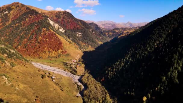 Top view of picturesque mountain valley with village and river. Footage. Beautiful mountain landscape with dry river and village in autumn. Colorful mountain valley on Sunny autumn day — Stock Video