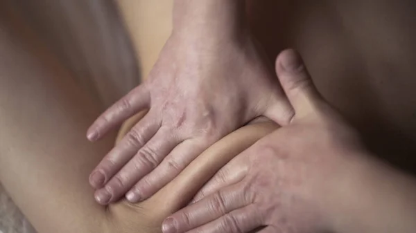 Młody męski masażysta robi profesjonalny masaż klientce w profesjonalnym salonie masażu. Akcja. zbliżenie człowiek ręce masowanie kobieta plecy, pojęcie zdrowie i pielęgnacja ciała. — Zdjęcie stockowe