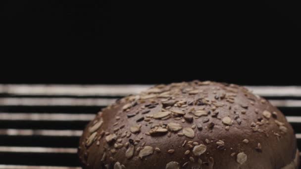 Випічка житнього хліба з зернами і насінням в духовці на грилі. Стокові кадри. Крупним планом круглий хліб смачного і здорового хліба . — стокове відео