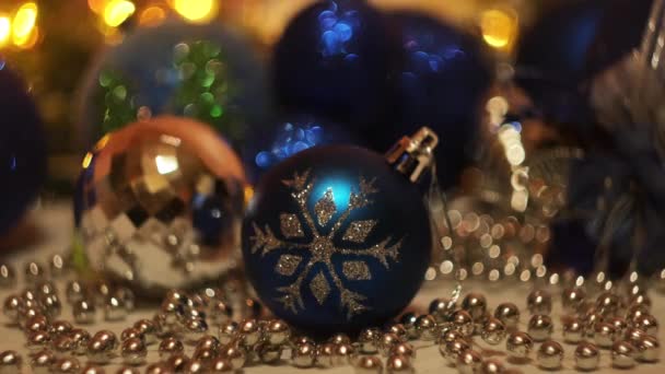 Karácsonyi játékok ünnepi villogó fények háttér. Fogantatás. Újévi ünnepek, közel a gyönyörű kék játék labda egy hópihe és fényes koszorú. — Stock videók
