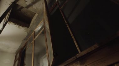 Fakir bir mahallede eski püskü bir balkonun içinde hareketli bir pencere. Stok görüntüleri. Pencerenin arkasında karanlık bir gökyüzü olan eski bir balkon manzarası..