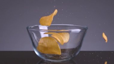 Çipler izole bir zemine düşüyor. Stok görüntüleri. Lezzetli cipsler düşer ve iştahı açar. Patates cipsi şeklinde zararlı atıştırmalıklar. En sevdiği abur cubur.