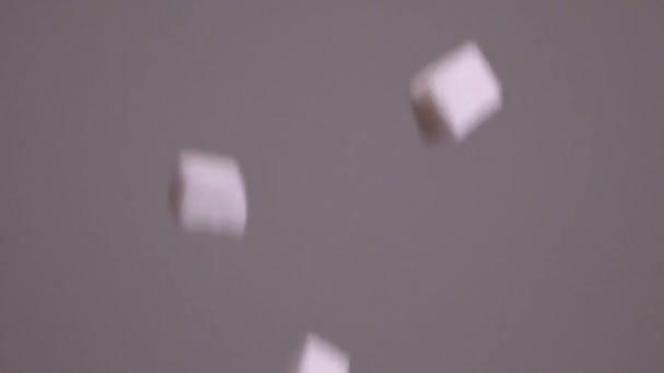 Sugar cubes fall on isolated background. Stock footage. Sugar cubes fall down. Sweets in large quantities are harmful to health. Sugar and sweets are 21st century addiction — Stock Video