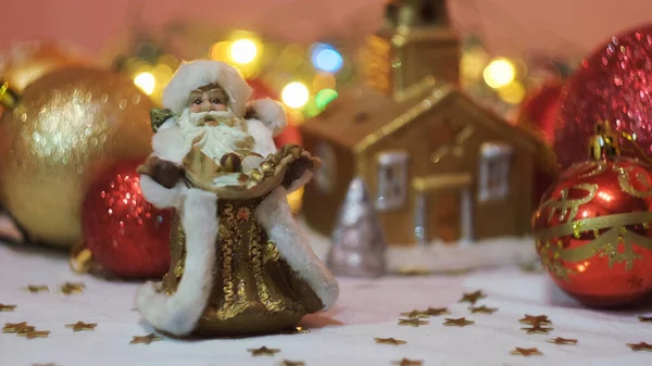 Minyatür oyuncak geleneksel Noel Baba çelenk ve Noel ağacı oyuncaklarının önünde. Kavram. Yeni yıl hediyelik eşya ve oyuncaklarının kapanışı. — Stok fotoğraf