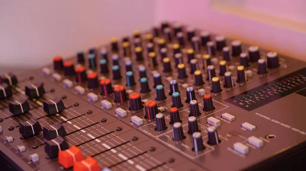 Close-up of man setting up mixing console. Media. Recording equipment with sound engineers mixing console. Recording Studio with small mixing console