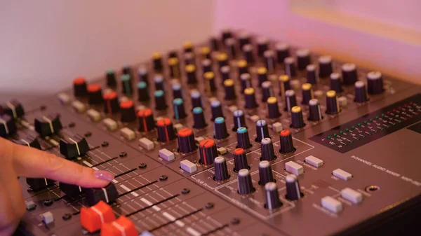 Close-up of man setting up mixing console. Media. Recording equipment with sound engineers mixing console. Recording Studio with small mixing console