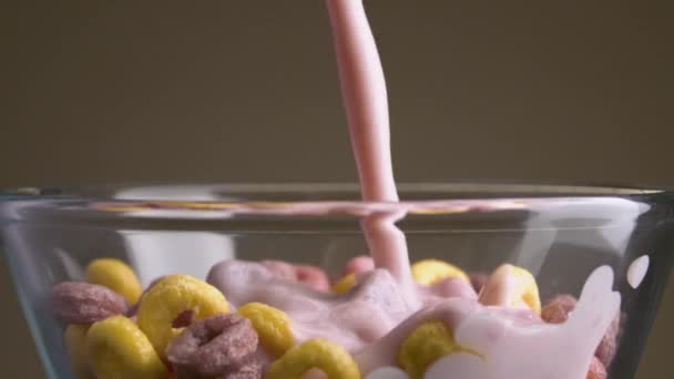 Νιφάδες με γάλα. Στικ. Κοντινό πλάνο σε πολύχρωμες γλυκές νιφάδες προσθέτουν γάλα. Γάλα με γλυκά πολύχρωμα δαχτυλίδια. Επιβλαβές γλυκό φαγητό — Αρχείο Βίντεο