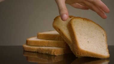 Bir parça ekmek alan adam. Stok görüntüleri. Adamın izole edilmiş arka planda taze dilimlenmiş ekmek aldığı yakın plan. Kare şeklinde kesilmiş taze beyaz ekmek.