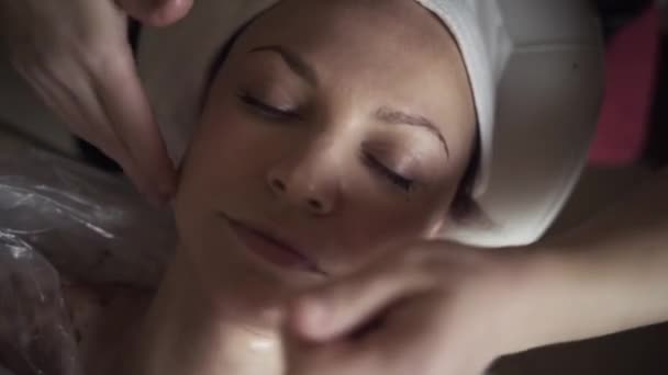 Косметическая процедура ухода за кожей лица. Начали. Закрыть вид на СПА расслабляющий массаж лица в клинике красоты, концепцию оздоровления и ухода за собой. — стоковое видео