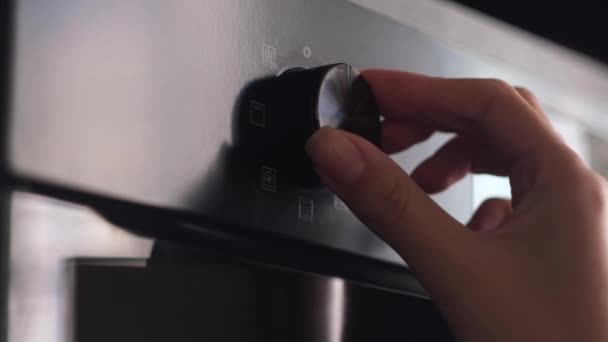 Close up of woman hand turning round temperature oven handle in the kitchen at home. Concept. Kitchen utensils for easy cooking. — Stock Video