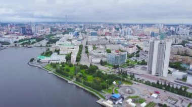 Merkezinde kanal olan modern şehrin en iyi manzarası. Stok görüntüleri. Yazın modern şehrin yeşil parklarıyla güzel bir kanal kıyısı. Nehirleri ve bulutlu havada yeşil parkları olan büyük şehir manzarası
