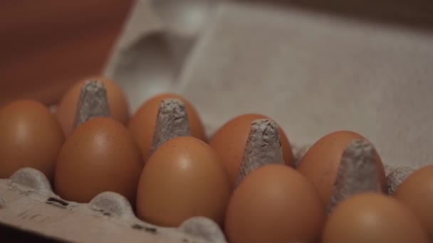 Ägg i en pappkartong på träbord bakgrund. Begreppet. Närbild av färsk kartong med hönsägg, hälsosam mat och kost. — Stockvideo