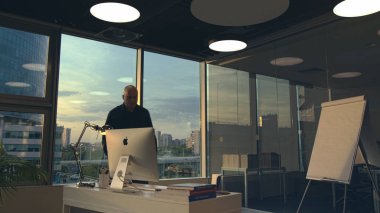 Moskova - Rusya, 09.20.2020: modern ofis içi ve iş tasarımının bir detayı olarak yeni bir Apple Mac Bilgisayar sunumu. Stok görüntüleri. Kılsız iş adamı masaya geliyor.
