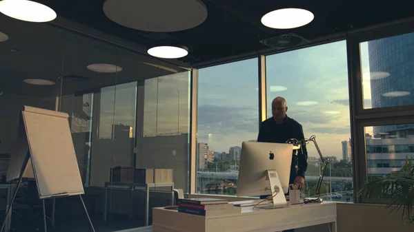 Moskwa - Rosja, 09.20.2020: nowoczesne wnętrze biura i prezentacja nowego komputera Apple Mac jako szczegół projektowania biznesowego. Materiał filmowy. Bezwłosy biznesmen podchodzi do stołu na — Zdjęcie stockowe