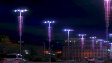 Gece vakti karanlık gökyüzü arka planında şehir caddesini aydınlatan güzel fenerler. Stok görüntüleri. Renkli ışıklandırmalı sokak lambaları, şehir dekorasyonu.. 