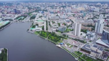 Merkezinde nehir olan modern şehrin en iyi manzarası. Stok görüntüleri. Merkezinde kanal ve yazın bol yeşillik olan güzel, modern bir şehir. Kanal kıyısında yüksek binaları olan güzel manzaralı bir şehir.