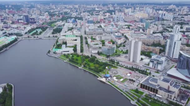 中央に川と近代的な都市のトップビュー。ストック映像だ。中心部に運河と夏に緑の多くを持つ美しい近代的な都市。運河のほとりに高層ビルが建ち並ぶ美しい景観都市 — ストック動画