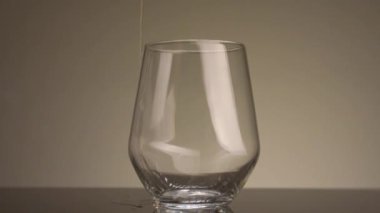 Şeffaf camlara dökülen sarı sıvının yakın çekimi. Stok görüntüleri. Sarı içecek izole edilmiş arka planda şeffaf camlara dökülür. Temiz bardakta bira.