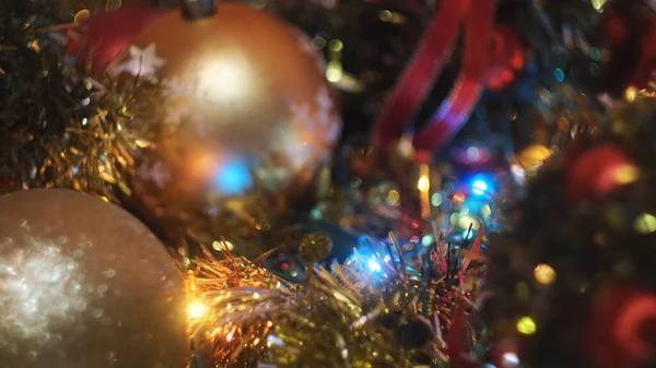 Most beautiful Christmas tree decorations for winter hollidays. Concept. Close up of woman hand putting red ball toy to the other toys and shining garland. — Stock Photo, Image