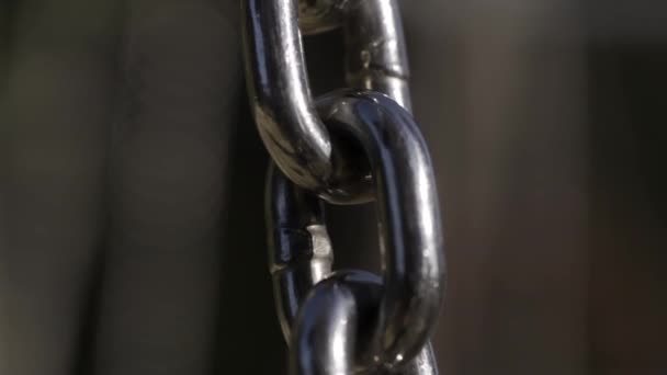 Strong chain linked together expressing connectedness. Action. Close up of moving silver metal chain on blurred background.