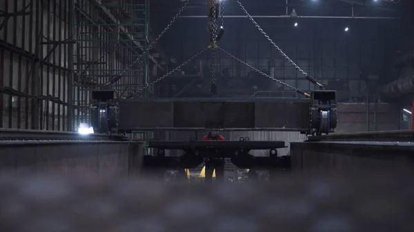 Plataforma de vagones sobre raíles en la fábrica. Clip. Plataforma de metal de tren con ruedas se puso en rieles en la fábrica. Creación de trenes en la planta de construcción de máquinas — Foto de Stock