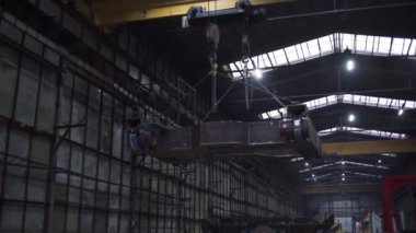 Santraldeki tren iskeleti. Şarjör. Tren tekerlekleri olan platform fabrikada zincirlerle askıya alınmıştır. Fabrikada zincirlenmiş tekerlekleri olan tren iskeleti.