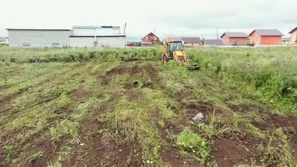 Excavator clears grass on land. Clip. Bulldozer clears grass on land plot. Bulldozer prepares plot of land for construction of country house — Stock Footage Excavator clears grass on land. Clip. Bulldozer clears grass on land plot. Bulldozer prepares plot of land for construction of country house Royalty Free Stock Footage