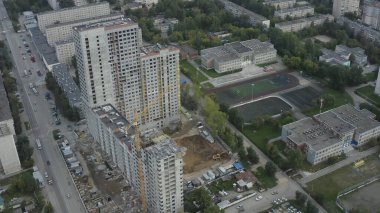 Yazın inşaat halindeki çok katlı binanın üst manzarası. Stok görüntüleri. Daire kiralamak için çok katlı büyük bir bina inşa ediliyor. Konut inşaatı devam ediyor.